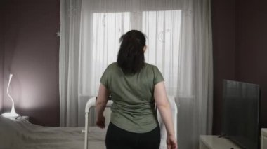 Evde koşu bandında antrenman. Kadın kilo vermek için kardiyo egzersizi yapıyor.