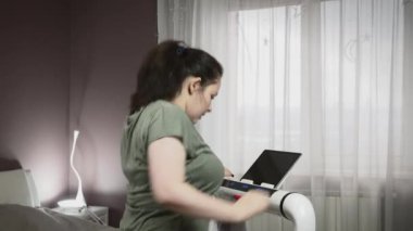 Kadın evde koşu bandında yoğun koşma egzersizleri yapıyor. Evde fitness
