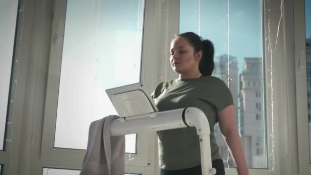 La mujer está entrenando en la cinta de correr, utilizando nueva tecnología inteligente. Máquina de correr eléctrica — Vídeo de stock