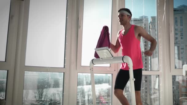 Důvěryhodný muž v růžových šatech kráčí na běžícím pásu. Muž trénuje na chytrého trenéra — Stock video