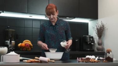 Mutfaktaki kadın. Olgun kadın kek pişiriyor. Evde fırın var. Ev yapımı kek.