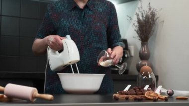 Baker malzemeleri kasede karıştırıyor, pasta için hamur pişiriyor.