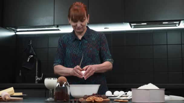 Donna sta rompendo uova crude con coltello in ciotola nella cucina domestica moderna — Video Stock