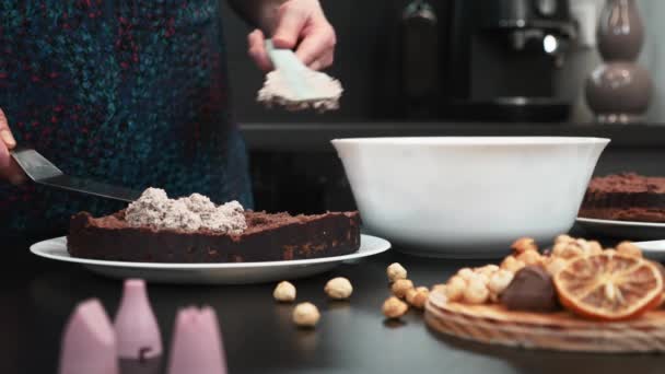 用奶油和饼干做蛋糕的女人女性在巧克力蛋糕上涂奶油 — 图库视频影像