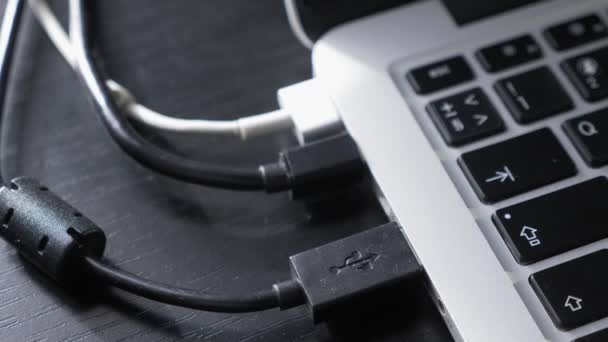 Человек отключает кабель USB от ноутбука. Человек отсоединяет провод к компьютеру — стоковое видео