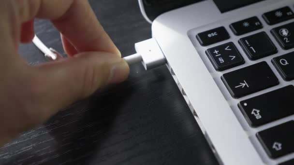 Человек подключает зарядное устройство для ноутбука. Ноутбук с разъемом USB типа C для зарядного устройства — стоковое видео