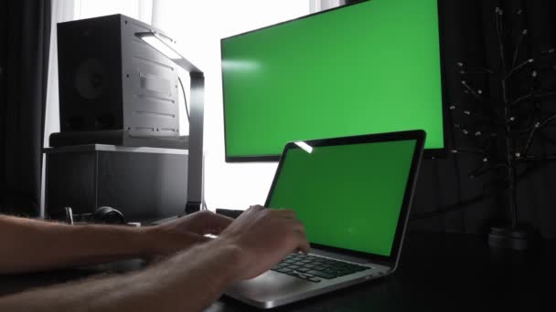 Chiave cromatica schermo verde. L'uomo sta lavorando su computer portatile con schermi verdi — Video Stock