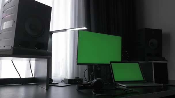 Moderno lugar de trabajo con ordenador portátil, pantallas verdes y monitores de estudio en la oficina — Vídeos de Stock