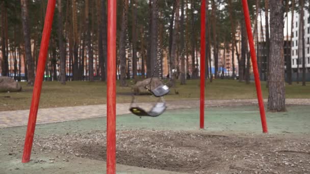 Balanço de metal vazio está balançando no parque da cidade. Parque infantil vazio — Vídeo de Stock