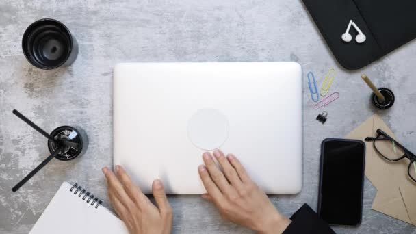 Kadın dizüstü bilgisayarı açıp çalışma masasında çalışmaya başlıyor. Ofis işyeri — Stok video