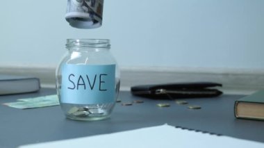 Bozuk paralarla dolu cam kavanozdaki dolar banknotları. Tasarruf. Tasarruf kavanozunda. Finans