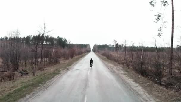 Велосипедист на открытом воздухе. Человек в велосипедной одежде ездит на велосипеде по пустой дороге — стоковое видео