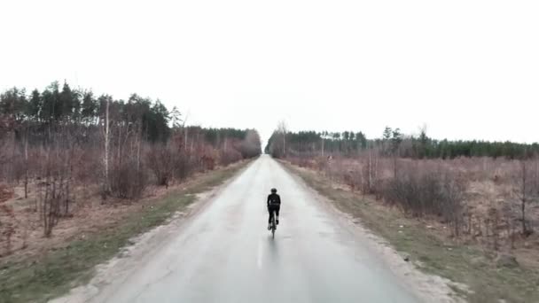 田舎道のサイクリスト。国立公園や森の中を空の道で走る — ストック動画