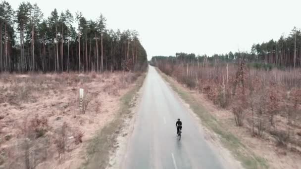 Bisikletli siyah elbiseli ve kask takan bisikletçi. Bisiklet sporu etkinliği — Stok video