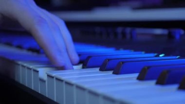 Kayıt stüdyosunda synthesizer çalan adam. Piyanist klavyede müzik besteliyor