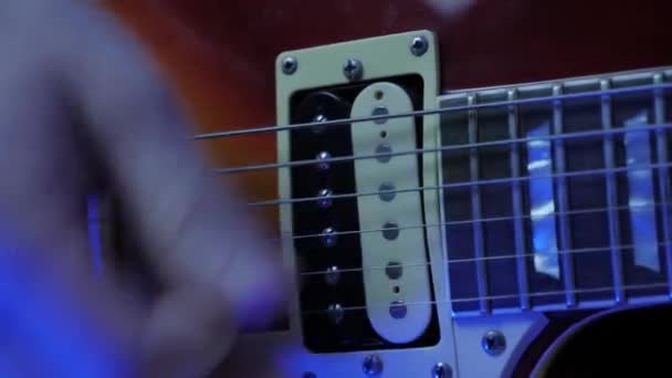 Guitarrista profesional manos en luz de neón tocar la guitarra eléctrica en concierto — Vídeo de stock