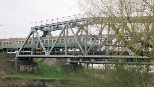 Passenger train passing over bridge over river. Train passes railway bridge — Vídeos de Stock