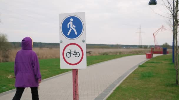 Road sign prohibits cyclists from riding on footpath. Sign "pedestrian walkway" — Video