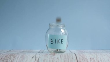 Bisiklet için para biriktiriyorum. Yazı bisikletiyle cam kavanoza bozuk para atmak.