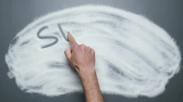 Sweet sugar written on sugar background. Male hand writes words sweet sugar — Stock Video