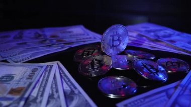 BTC paraları ve dolarlarla ışığı döndüren ve yansıtan parlak bitcoin