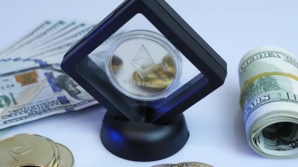 Λαμπερό χρυσό μέταλλο ethereum ETH νομίσματα περιστρέφεται σε λευκό φόντο με χρήματα — Αρχείο Βίντεο