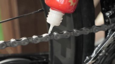 El bisiklet zincirini yağlar. Bisiklet zinciri için yağ kayganlaştırıcı. Bakım ve bakım bisikleti