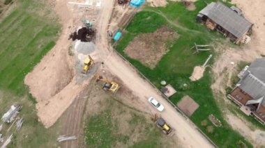 Kış kayak merkezindeki inşaat alanında traktörler ve buldozerler. Kulübelerin binaları