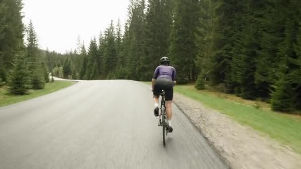 Entrenamiento en bicicleta. Ciclismo colina arriba en el bosque verde. Ciclista pedaleando en bicicleta. Mujer montar en bicicleta — Vídeo de stock