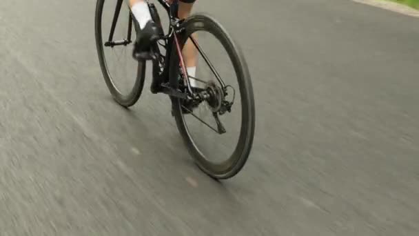 Bisikletle pedal çeviren kadın bisikletçi bacağı. Bisiklet tekerleği ve bisiklet teçhizatı çalışıyor. Triatlon kadın bisikleti — Stok video