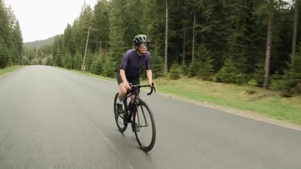 Női biciklizés. Kerékpáros biciklizés. Atléta lovagol közúti kerékpár a hegyi úton — Stock videók