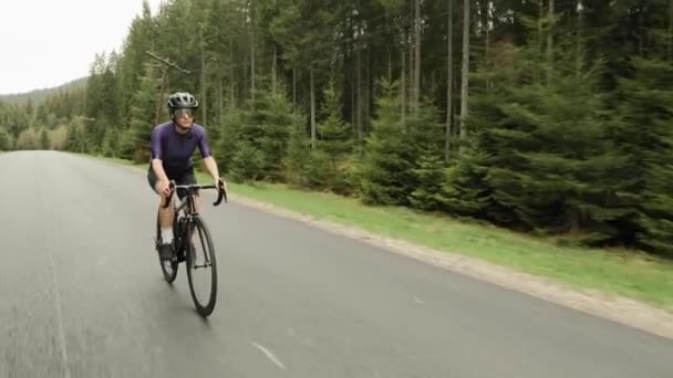 Велоспорт. Езда на велосипеде в горах. Женщина ездит на велосипеде по горной дороге. Триатлон — стоковое видео