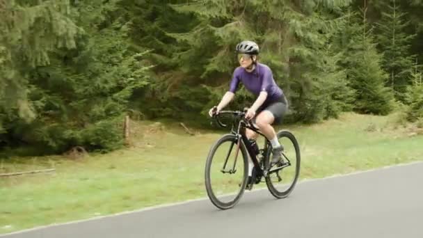 Egy nő biciklizik a hegyekben. A biciklis biciklizik. Kemény edzés. Triatlon — Stock videók