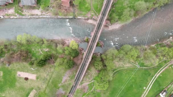 Вид с воздуха на железнодорожный мост в горах. Железнодорожный мост через реку — стоковое видео