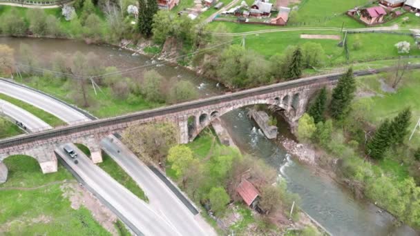 Stenen viaduct brug over de rivier. Spoorbrug in bergdorp — Stockvideo