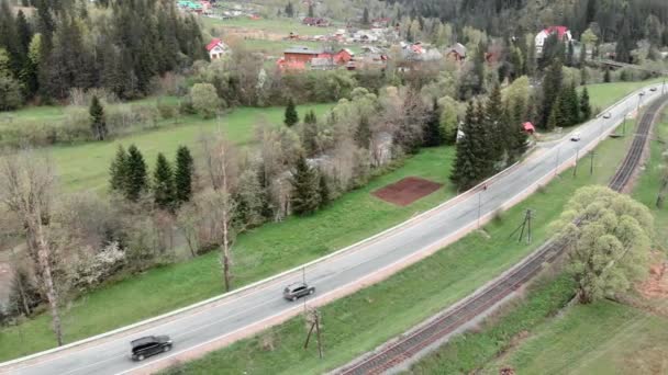 Karpatya dağlarında hız otoyolu. Araç ve demiryolu üzerinde uçan insansız hava aracı — Stok video