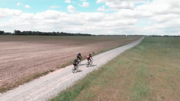 Ciclistas andando em bicicletas de cascalho na estrada rural no campo. Pessoas de bicicleta na estrada de cascalho — Vídeo de Stock