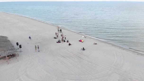 Persone che si rilassano sulla spiaggia, festa vacanza ricreativa. Festa estiva sulla spiaggia al tramonto — Video Stock