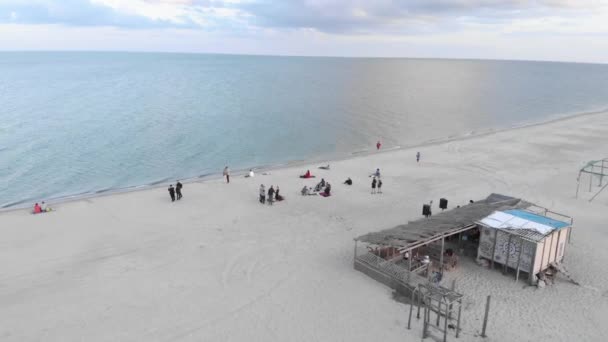 Letnia impreza na plaży o zachodzie słońca. Przyjaciele bawią się na plaży, piją piwo, śmieją się i relaksują — Wideo stockowe