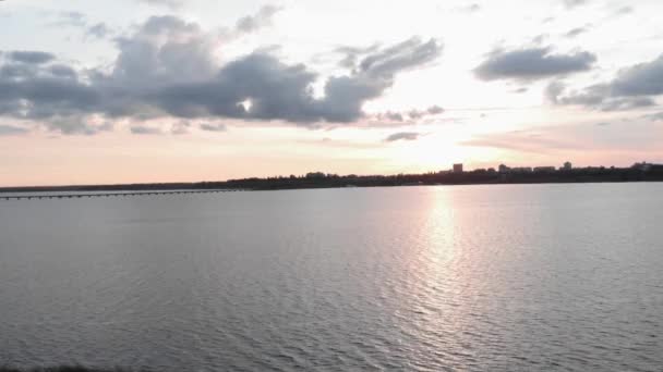 Όμορφο ηλιοβασίλεμα στη θάλασσα με σιλουέτα της πόλης στον ορίζοντα. Ηλιοβασίλεμα στην ακτή — Αρχείο Βίντεο