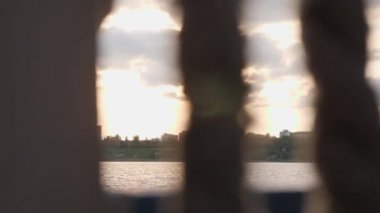 Gün batımında tekneden görüntü. Ufukta şehir binalarının siluetiyle güzel bir gün batımı.