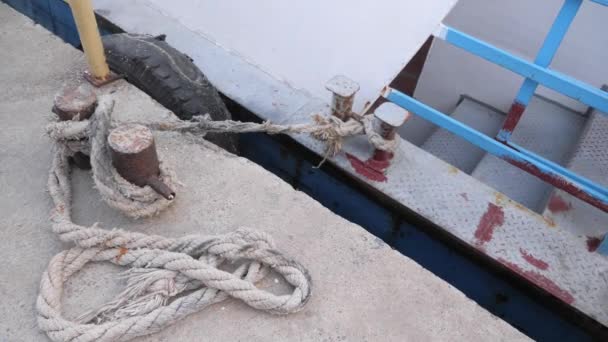 Rope tied to cleat of boat. Ropes of old sailboat. Rope for mooring lies on pier — Stock Video