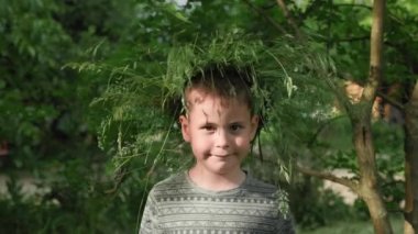 Çekici küçük bir çocuğun portresi. Çiçekli çocuk kameraya bakıyor ve gülümsüyor.