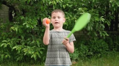 Tenis raketi olan sevimli bir çocuğun portresi. Mutlu yaz çocukluğu. Spor etkinliği