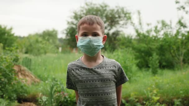 Ritratto di bambino in maschera protettiva medica blu che guarda la macchina fotografica — Video Stock