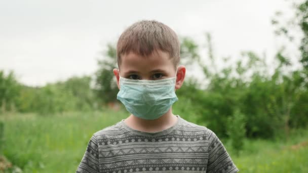 かわいい子供の男の子は保護医療マスクと笑顔を離陸します。ウイルス対策 — ストック動画