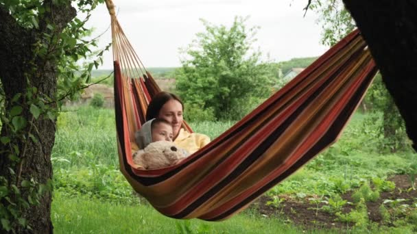 Moeder en zoon liggen in de hangmat en hebben plezier. Gelukkig gezin ontspannen op hangmat — Stockvideo