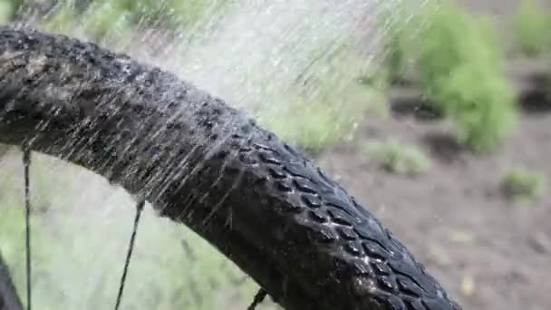 Lavaggio biciclette. L'uomo lava la ruota della bici con acqua. Lavaggio biciclette con tubo — Video Stock