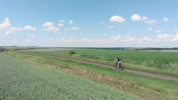 Çakıl taşı bisikletli bisikletçi. Çakıl yolunda bisiklet sürmek. Motosiklet süren kadın. — Stok video