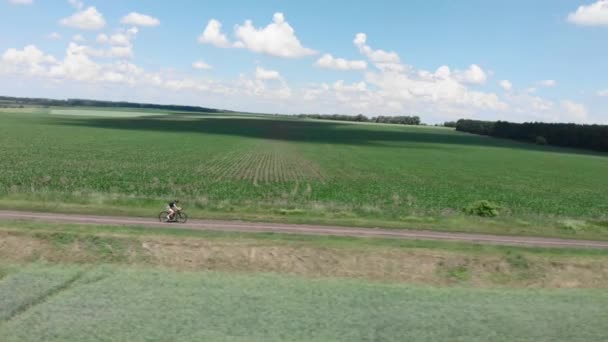 Ciclista su bicicletta di ghiaia. Pedalare su strada sterrata. Donna in bicicletta su strada sentiero — Video Stock